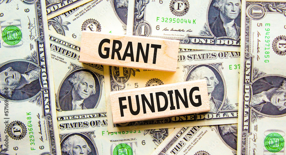 picure is sowing dollar bills and two wooden blocks with the words 'grant funding' categorical grants